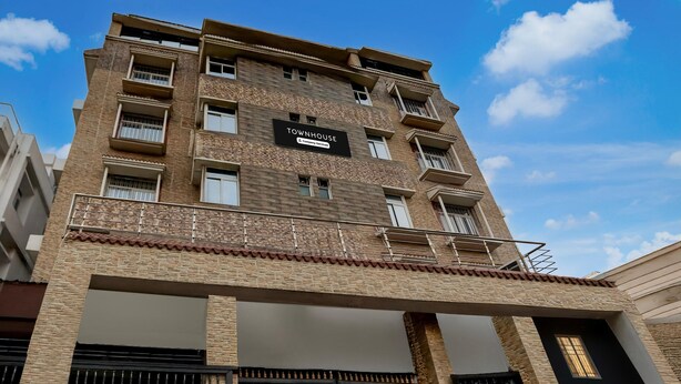 Un immeuble à plusieurs étages sur lequel on peut lire l’inscription : « TOWNHOUSE, services de qualité supérieure ».