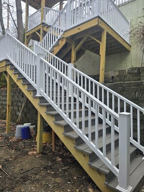 Eine Holztreppe mit weißen Geländern, die zu einem Balkon führt.