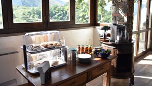 A breakfast buffet with pastries, beverages, and a coffee machine. - B&B La Casetta (Verbicaro)