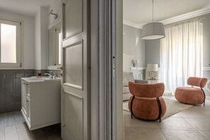 Un baño moderno con un espejo grande, un lavamanos y una zona de ducha.