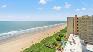 A beach view with a hotel building adjacent to the shore. - Ocean Bay Club 1510-4 Bedroom-Indoor/Outdoor Pools (North Myrtle Beach)