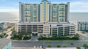A multi-story hotel with a parking garage, located near a beach. - Ocean Bay Club 1510-4 Bedroom-Indoor/Outdoor Pools (North Myrtle Beach)