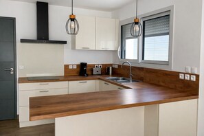 A modern kitchen with a wooden countertop, stainless steel sink, and pendant lights. - Cosy house 4 bedrooms, Saint-Coulomb center, beaches 5mn (Saint-Coulomb)