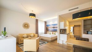 A modern hotel room with a sofa, a bed, a dining area, and a kitchen. - Sunny Suite I Graz-süd I 2 Pers 24-7 Check-in (Graz)