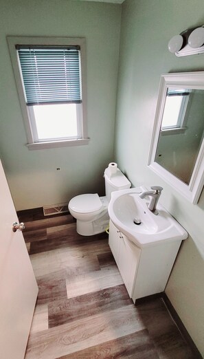 Ein Badezimmer mit Toilette, Waschbecken und Fenster.