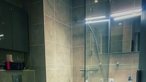A modern bathroom with a glass-enclosed shower, a toilet, a sink, and a cabinet. - Studio by the sea with pool (Le Grau-du-Roi)