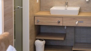 Een moderne badkamer met een wastafel, spiegel en handdoekhouder.