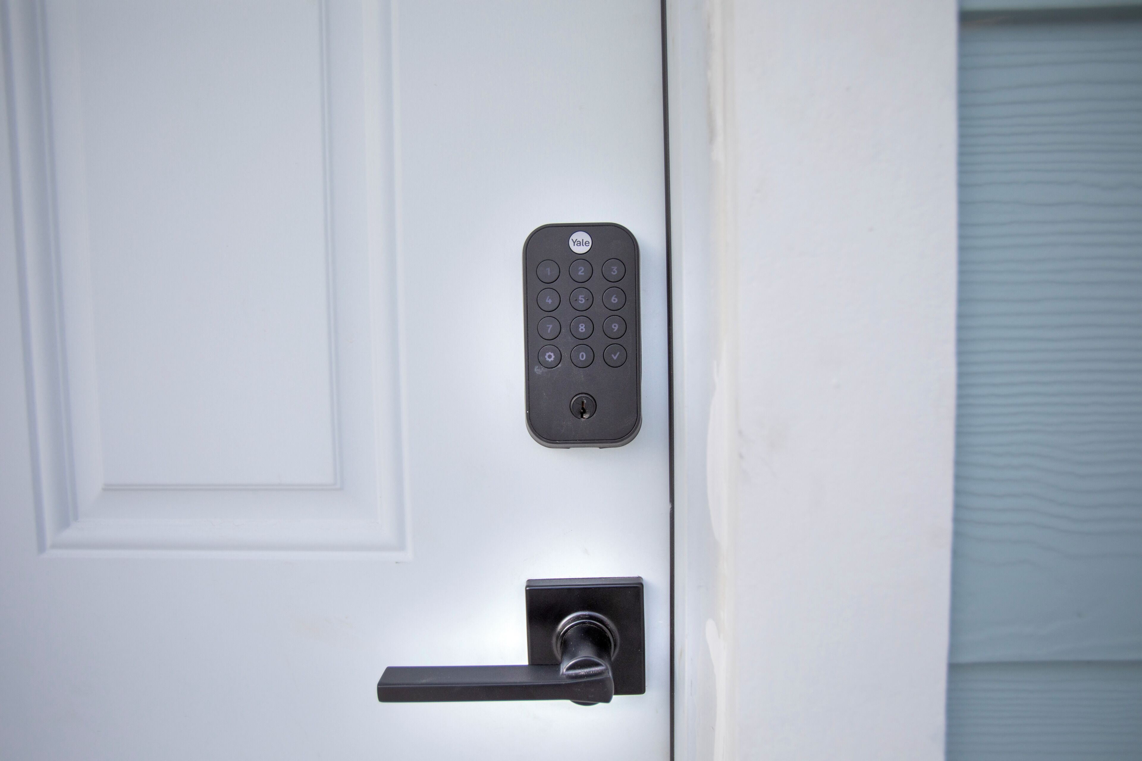 A door with a Yale keypad lock and a keyhole.