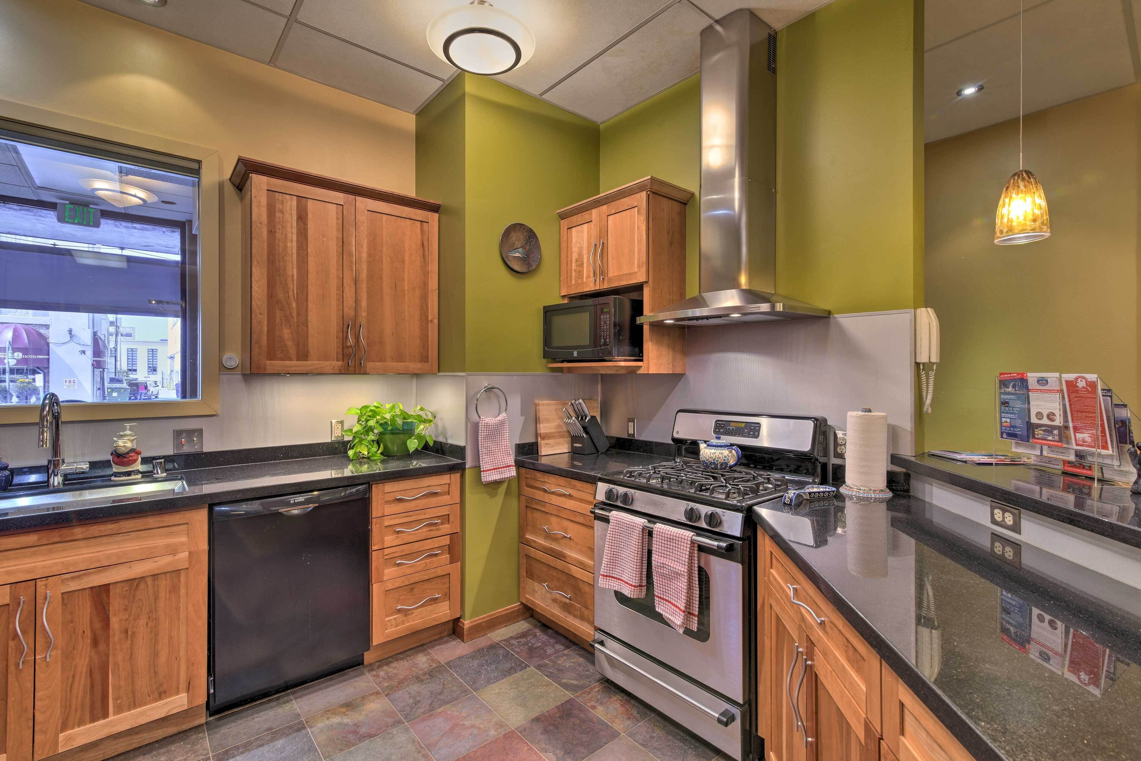 A kitchen with wooden cabinets, a stainless steel stove, a microwave, and a sink.