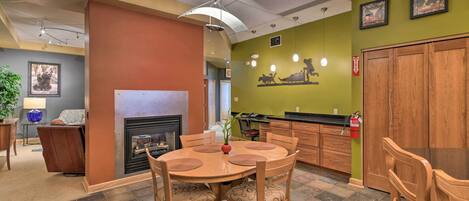 A dining area with a round wooden table, chairs, and a fireplace.