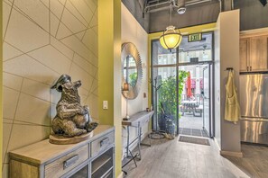 Une cuisine moderne dotée d’un réfrigérateur en acier inoxydable, d’un plan de travail en bois et d’un luminaire suspendu.