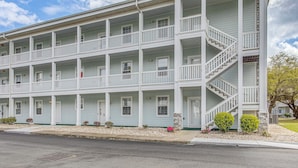 A multi-story building with balconies, a central staircase, and a front entrance. - Family Favorite 1st Floor Pool Golf (Myrtle Beach)