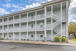 A multi-story building with balconies, a central staircase, and a front entrance. - Family Favorite 1st Floor Pool Golf (Myrtle Beach)