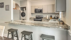 A modern kitchen with a marble countertop, stainless steel appliances, and a built-in oven. - Family Favorite 1st Floor Pool Golf (Myrtle Beach)