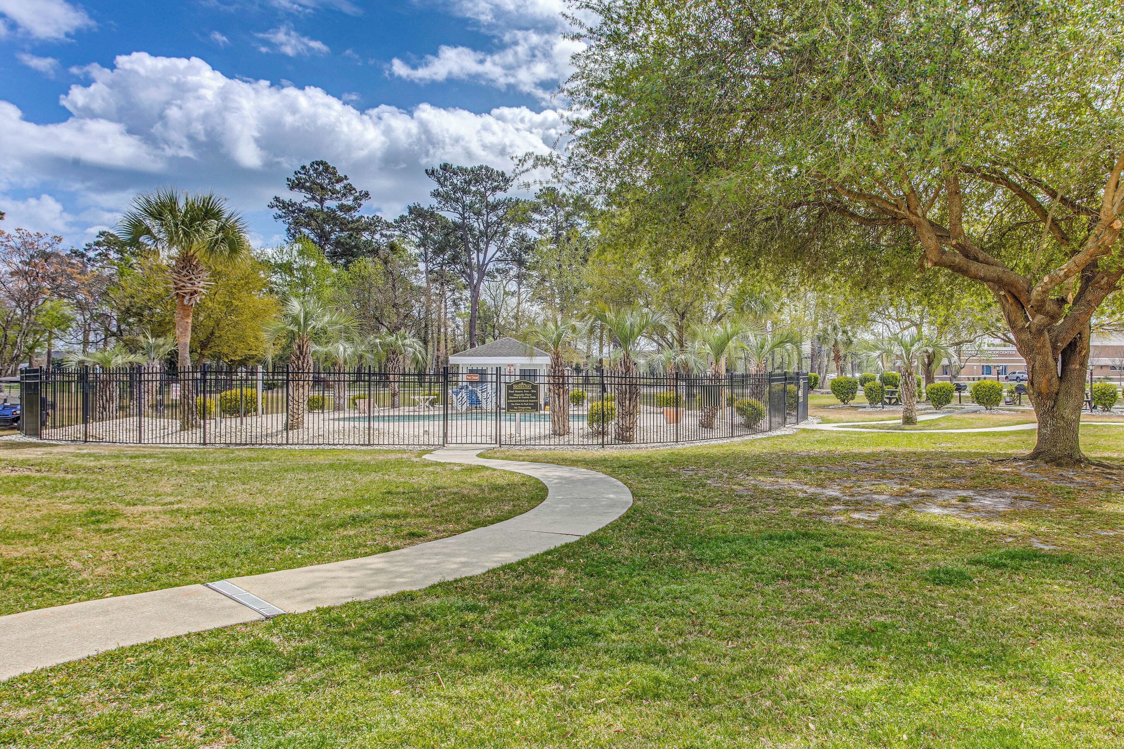 A park with a gazebo, a fenced area, and a pathway.