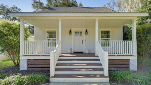 A two-story house with a porch, steps, and a front door. - 5 Mi to Pier Village: Coastal Jade Cottage (St. Simons Island)