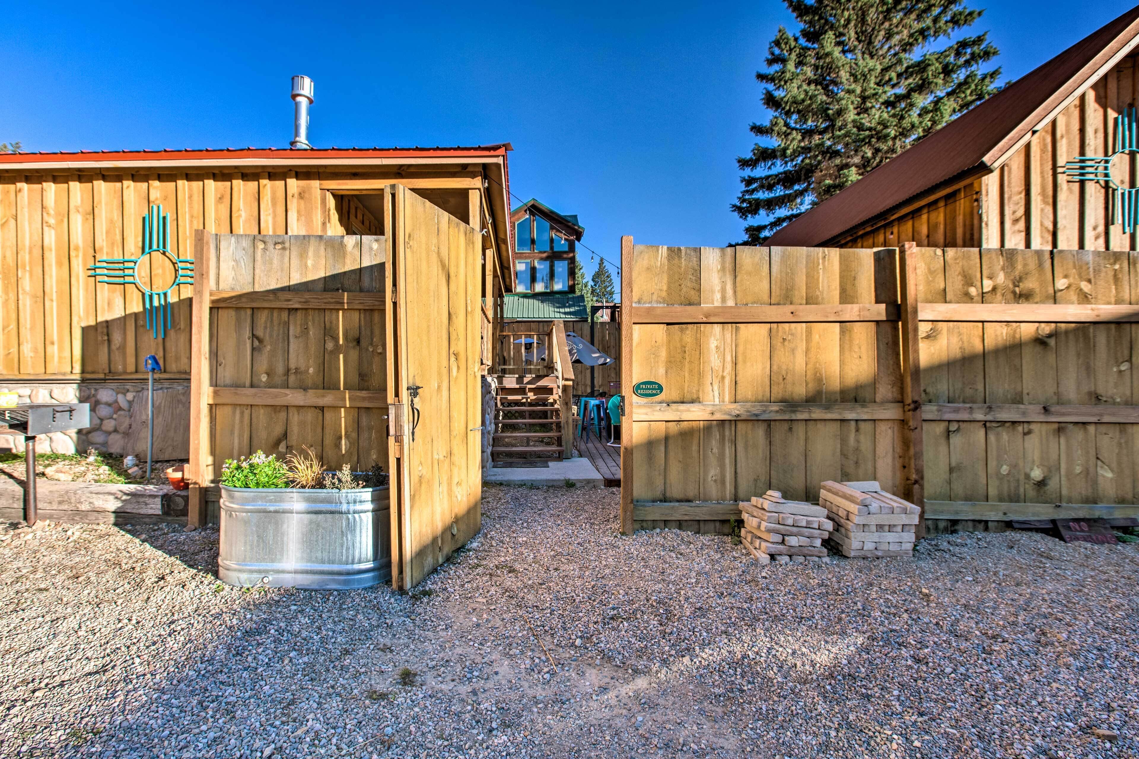 A wooden building with a metal barrel and a stack of bricks.