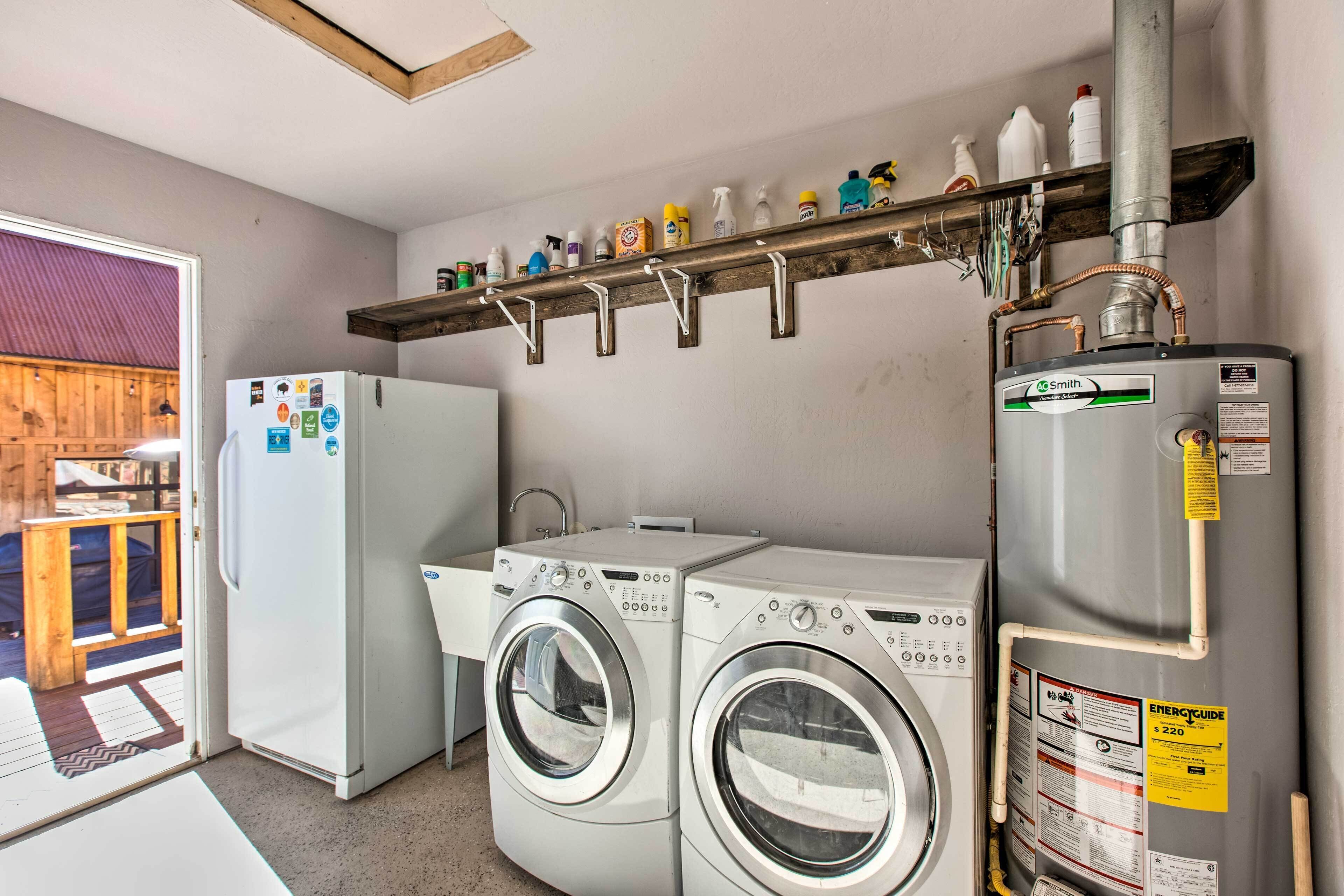 A laundry area with two washing machines, a refrigerator, and a water heater.