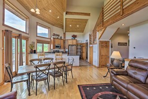 A spacious kitchen with wooden cabinets, a central island, and a dining area with a wooden table and chairs. - 2 Mi to Granby Ranch: Granby Home w/ Hot Tub! (Granby)