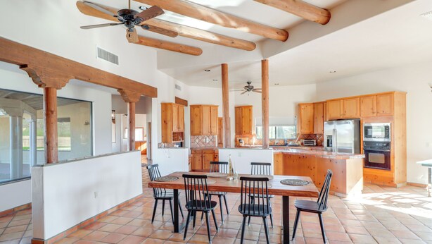 A spacious kitchen with wooden cabinets, a central island, and a dining area with chairs. - Pool & Views! Luxury Sonoran Desert Oasis Retreat (Tucson)