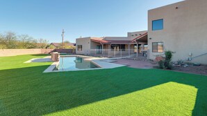 A modern house with a swimming pool, a well-maintained lawn, and a clear sky. - Pool & Views! Luxury Sonoran Desert Oasis Retreat (Tucson)