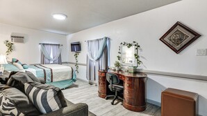 A bedroom with a bed, a desk, a chair, a couch, and a small table. - Patio w/ Garden Views! Tranquil Tucson Townhome (Tucson)