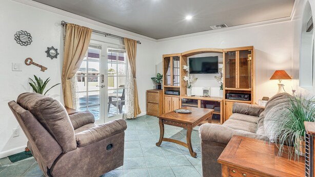 A living room with a sofa, a coffee table, a TV, and a cabinet. - Patio w/ Garden Views! Tranquil Tucson Townhome (Tucson)