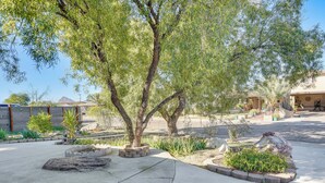 A landscaped outdoor area with trees, a concrete pathway, and a building in the background. - Patio w/ Garden Views! Tranquil Tucson Townhome (Tucson)