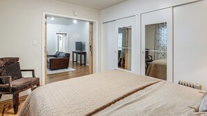 A bedroom with a bed, a chair, a desk, and a wardrobe. - Walkable Dtwn Oakland Apt w/ Shared Rooftop! (Oakland)