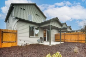 A two-story house with a covered patio, a wooden fence, and a landscaped backyard. - Newly Built PNW Home: 1 Mi to WSU & Med Center (Vancouver)