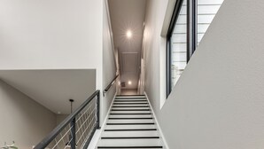A modern staircase with a metal railing, leading to a door at the top. - Hot Tub, Lake View! Lakefront Marble Falls Home (Marble Falls)