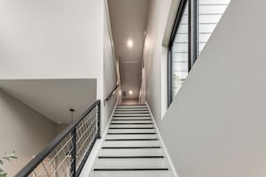 A modern staircase with a metal railing, leading to a door at the top. - Hot Tub, Lake View! Lakefront Marble Falls Home (Marble Falls)