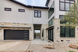 A modern two-story house with a garage, stone facade, and large windows. - Hot Tub, Lake View! Lakefront Marble Falls Home (Marble Falls)