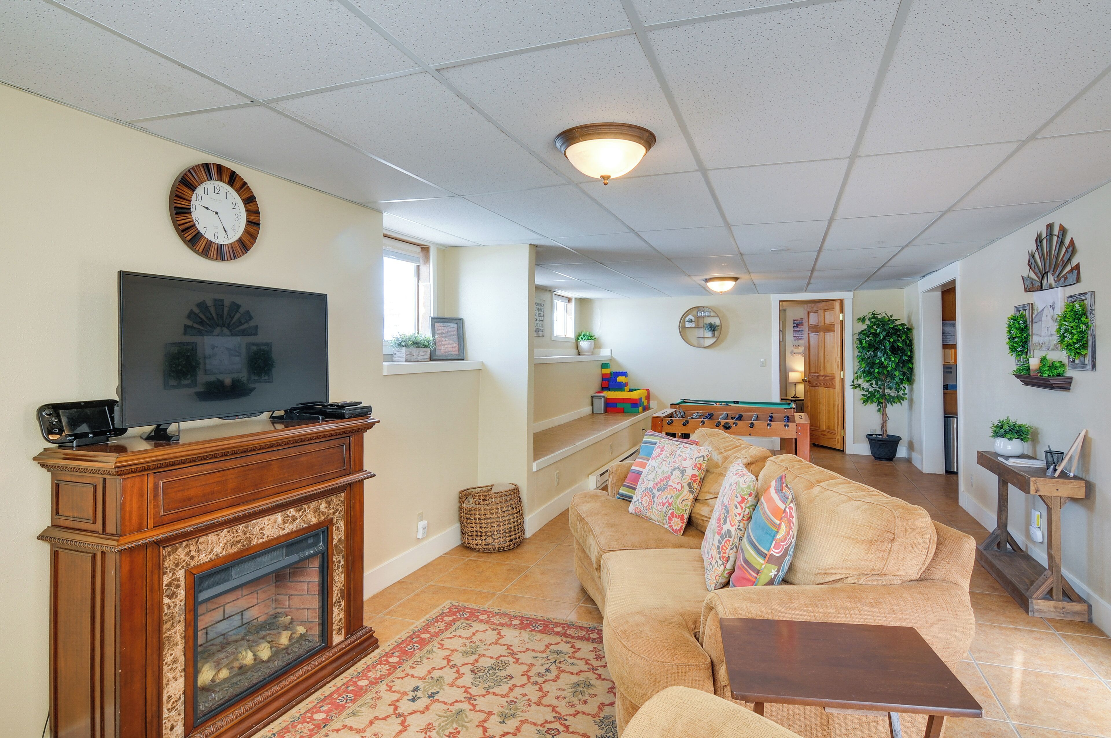A living room with a fireplace, television, sofa, and a dining area with a table and chairs.