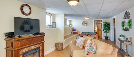 A living room with a fireplace, television, sofa, and a dining area with a table and chairs.