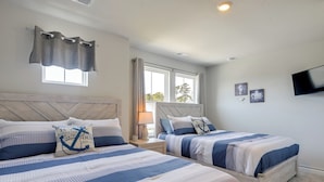 A bedroom with two beds, a window, a TV, and a nightstand with a lamp. - 2 Mi to Ocean Isle Beach! Coastal Getaway w/ Patio (Ocean Isle Beach)