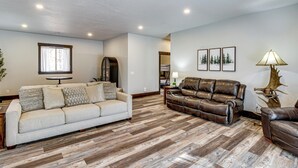 Un salon avec un canapé beige, un canapé en cuir marron et un plancher en bois.