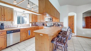 Une cuisine spacieuse avec des meubles en bois, un îlot central et des tabourets de bar.