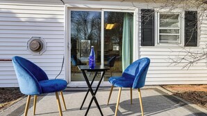 A house with a sliding glass door, two blue chairs, and a table with a bottle. - Pet-friendly Home w/ Patio: 4 Mi to Saratoga Spa! (Saratoga Springs)