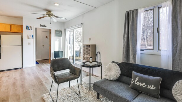 A living room with a sofa, a chair, a small table, a ceiling fan, and a window with curtains. - Pet-friendly Home w/ Patio: 4 Mi to Saratoga Spa! (Saratoga Springs)