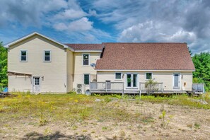 A two-story house with a front porch and a satellite dish. - Explore the White Mountains! Spacious Rural Home (Thornton)