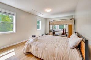 A bedroom with a large bed, a desk, and a chair. - Explore the White Mountains! Spacious Rural Home (Thornton)