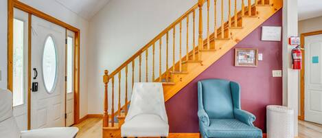 A staircase with wooden balusters and a white wall with a framed picture.