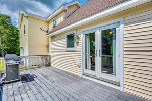 A house with a covered deck, a satellite dish, and a sliding glass door. - Explore the White Mountains! Spacious Rural Home (Thornton)