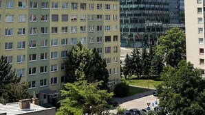 A multi-story building with a flat roof, a parking area, and a clear sky. - Beautiful 1-bedroom apartment in cozy Košický kraj perfect for relaxing (Košický kraj)
