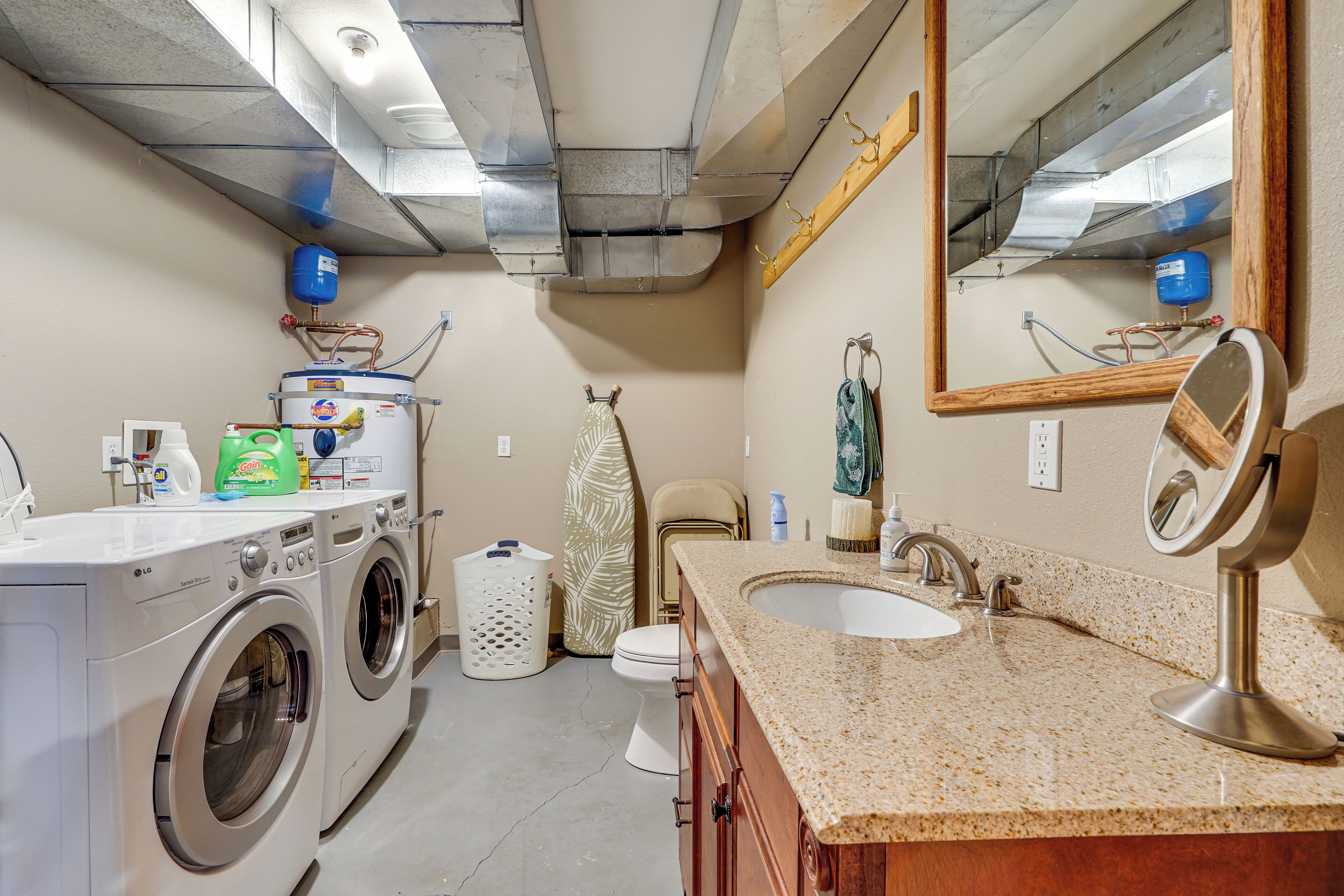 A laundry area with a washing machine, dryer, and a water heater.