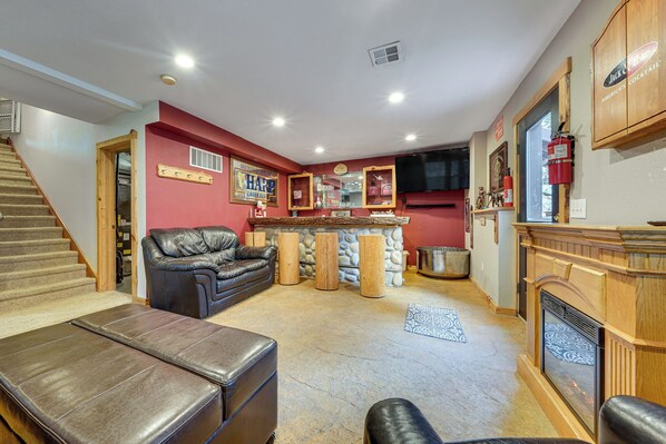A living room with a fireplace, a bar area, and a staircase. - 1 Mi to Cle Elum Lake! Family Cabin w/ Game Room (Cle Elum)
