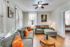 Sala de estar com sofá, mesa de centro e ventilador de teto.
