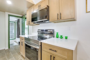 A kitchen with wooden cabinets, a stainless steel oven, and a microwave. - Lakeside Charm! Updated Home Near Mtn Creek Resort (West Milford)
