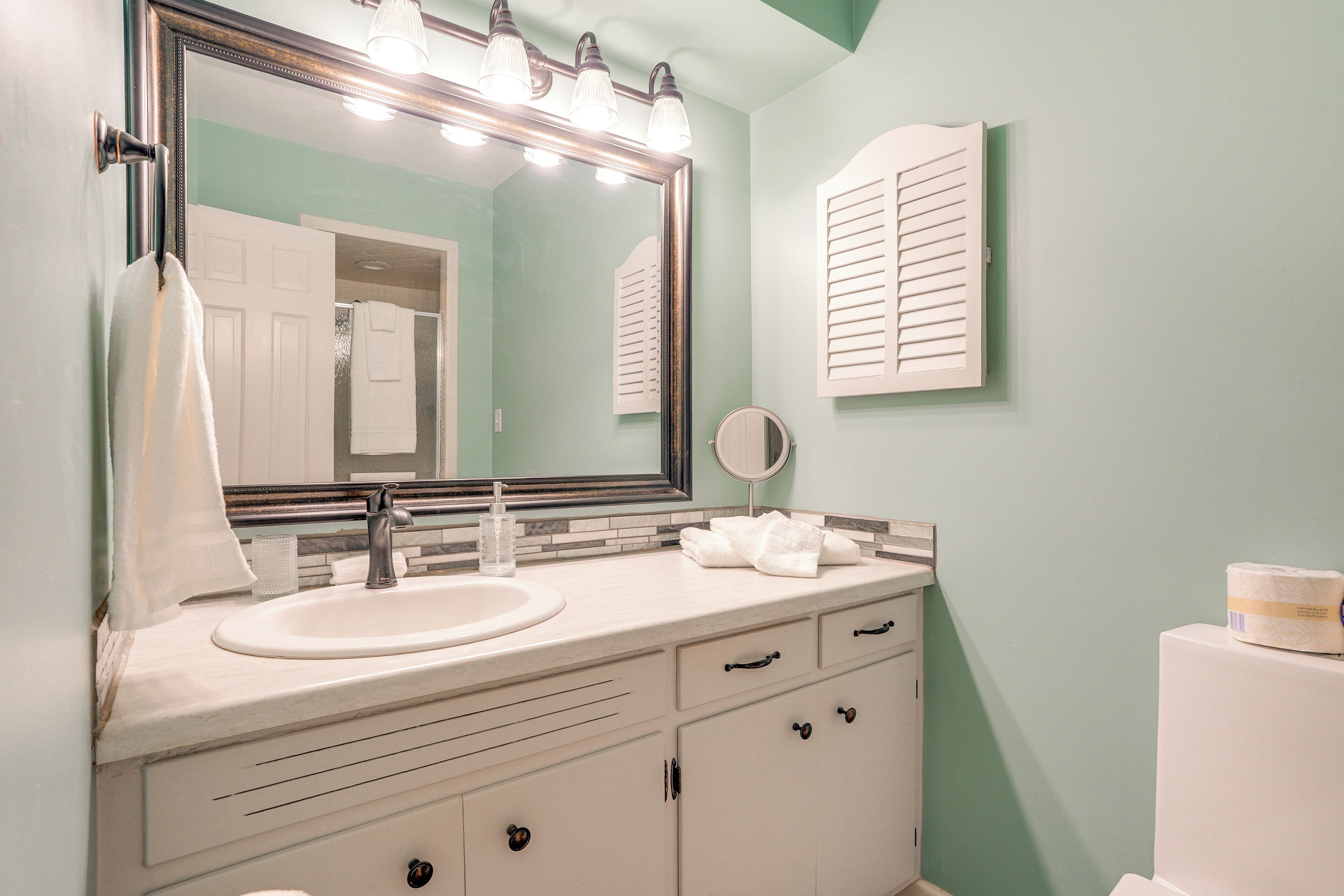 A bathroom with a sink, mirror, and toilet.
